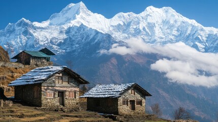 Obraz premium Traditional stone houses nestled in a Himalayan village with snow-capped mountains in the background.