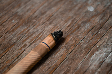 a used white cigarette on a wooden background
