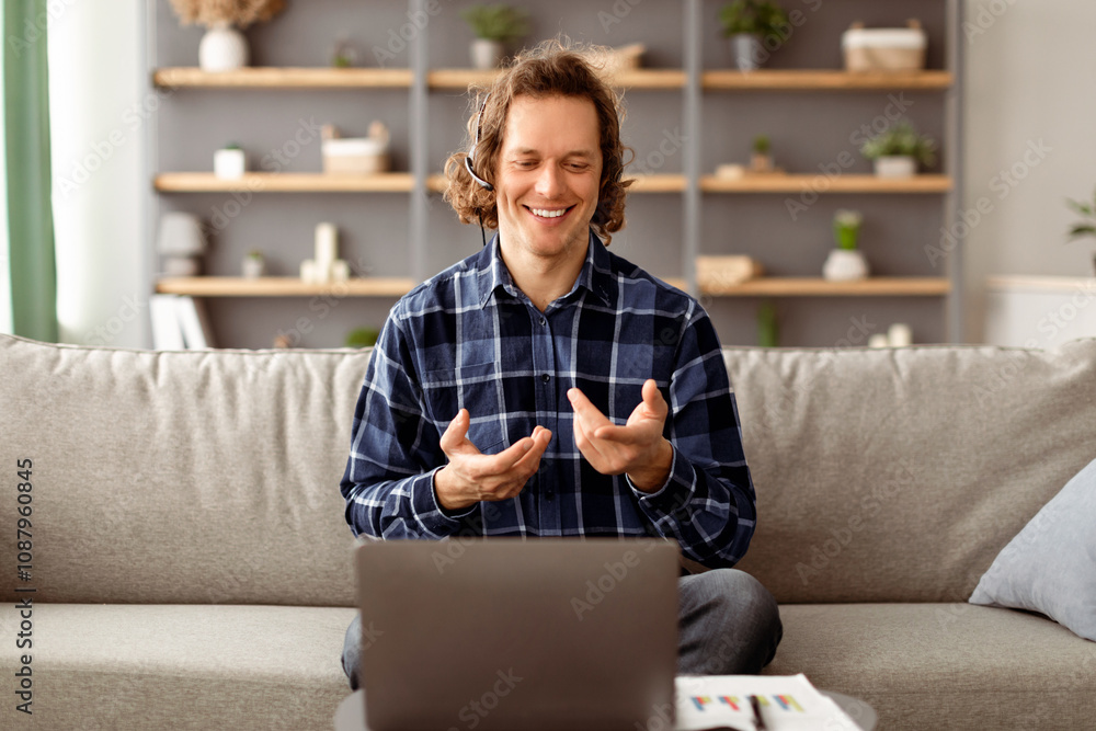 Poster freelancer man using laptop making video call talking to computer webcam communicating online sittin