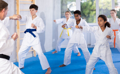 Group of karate kids practicing karate technique in gym..