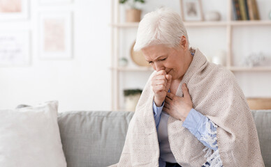 Sick Senior Woman Covered In Blanket Coughing Hard At Home, Having Coronavirus Symptomes, Sitting...
