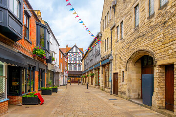 View from Parchment Street looking at High Street in the medieval old town of Winchester, England, UK, a picturesque district full of half-timbered buildings of shops and cafes.