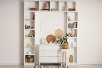 Interior of stylish living room with dresser, decor, bookshelves and books © Pixel-Shot