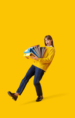 Shocked young businesswoman with a lot of folders on yellow background