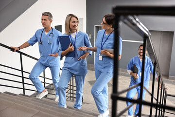 Fototapeta premium Healthcare workers walking up stairs in hospital
