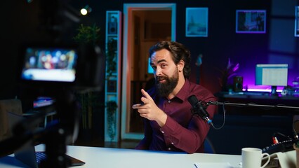 Excited influencer filming fashion vlog using professional camera, looking inside bags with purchases. Media star doing shopping haul while vlogging, recording with specialized gear, camera B