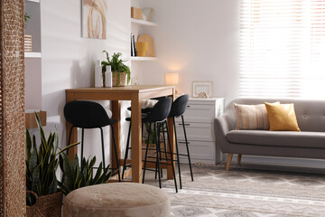 Bar stools near table in room. Interior design