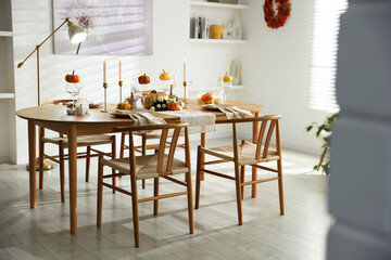 Stylish dining room with beautiful table setting and autumn decor