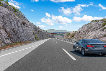 The car is driving along the highway surrounded by picturesque nature.