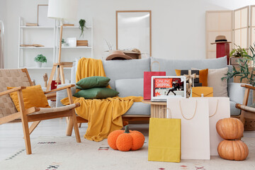 Laptop with open page of online store, purse, gift boxes and shopping bags at home. Autumn online shopping concept