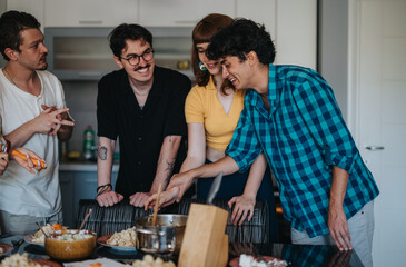 Group of friends gathered together in a modern kitchen, happily preparing a meal and sharing a joyful cooking experience.