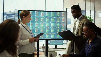 Business associates sharing ideas in a corporate briefing meeting, utilizing interactive boards to present detailed project reports and align on key performance indicators and objectives. Camera B.
