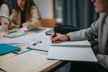 Focused students in a classroom setting, taking notes and engaging in learning. The image captures a collaborative and educational environment with study materials and attentive participants.