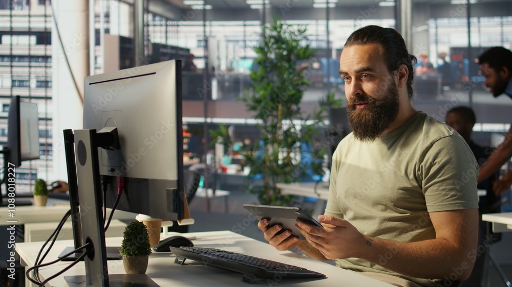 Poster employee looking at pc monitor, drinking coffee, checking data needed for finding business insights 