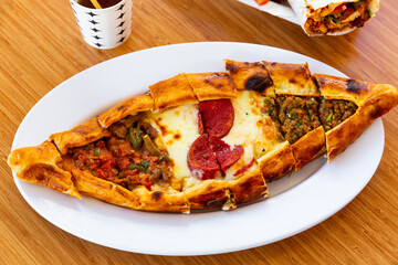 Pide with minced meat, vegetables and cheese. Turkish cuisine