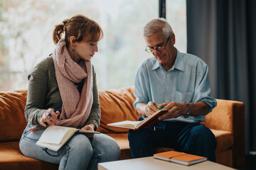 A senior professor assists a female student with her notes. They engage in a thoughtful discussion...