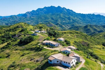 Fototapeta premium A birdâ€™s-eye view of a mountain village nestled in a valley surrounded by dramatic peaks