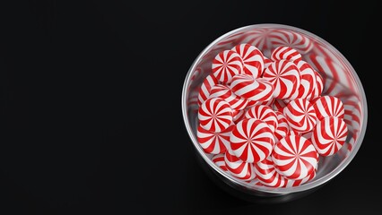 Christmas Peppermint Swirls on Glass Pot on Dark Background.