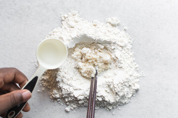 Overhead view of scallion pancake dough being made on a marble countertop, top view of cong you bing dough being mixed with chopsticks, process of making scallion pancakes 