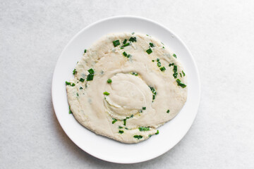 Overhead view of raw chinese scallion pancakes on a white plate, top view of homemade scallion pancakes, process of making cong you bing