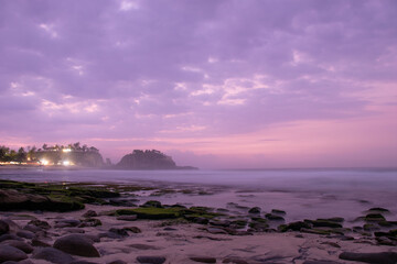 the beautiful view of a tropical beach in the morning, with white sand and coral rocks hit by ocean waves. Landscape images are taken with slow speed technique.