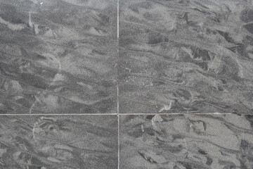 Grey gray tiles with a swirling marbled pattern close-up abstract textured background