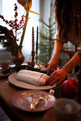 Woman cuts and serves a stolLen and wait for guests and sets the table. festive laying table,...