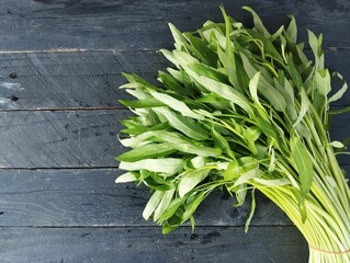 Ipomoea aquatica or fresh green Spinach on wooden table with top view angle setup 