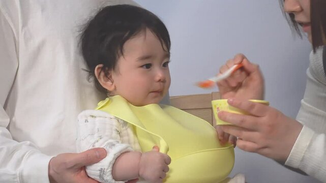 お母さんに離乳食を食べさせて貰う赤ちゃんとお母さんの横姿、固定撮影