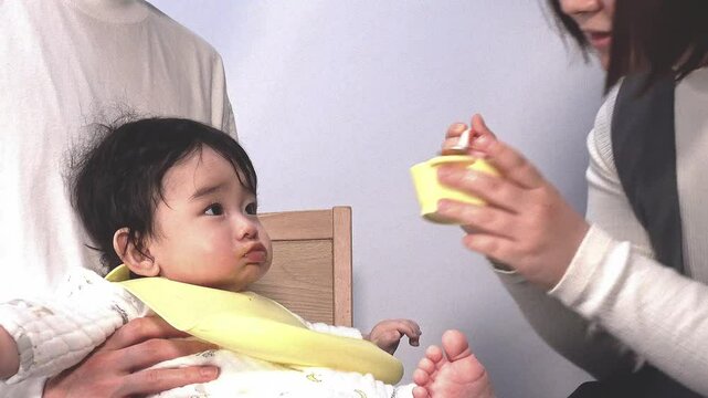 お母さんに離乳食を食べさせて貰う赤ちゃんとお母さんの横姿、固定撮影