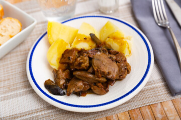 Healthy delicious dinner of roasted chicken liver with onion and garnish of baked potatoes..