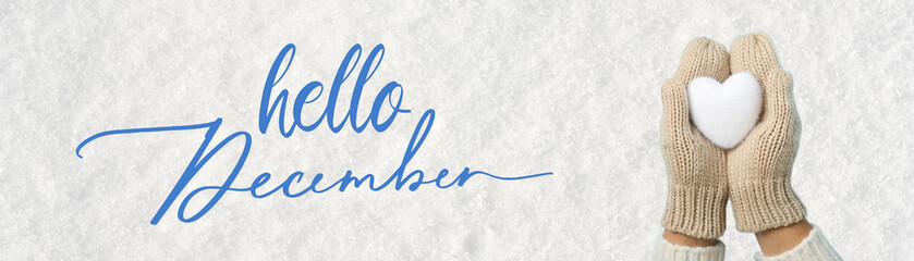 Hello winter, heart-shaped snowball in hands in mittens on a background of snow with text