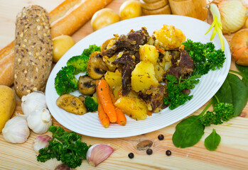 Juicy beef roast served with vegetables, mushrooms and herbs
