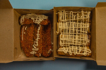 Crunchy banana cake, sweet banana cake with sweet topping, banana cake in a box and blue background