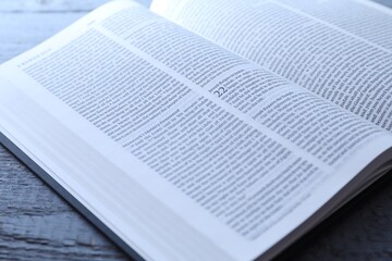 Open Holy Bible in English language on wooden table, closeup