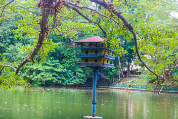 Pigeon cage in the middle of the lake at Gadjah Mada University surrounded by lush trees. Lake park in the city with pigeon house