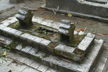 an old grave that is already overgrown with moss in the countryside of Magelang, Central Java, Indonesia