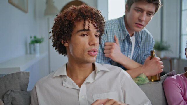 Closeup buddies talking home party. Young man holding beer communicating mate