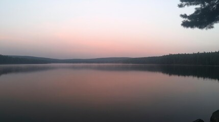 Fototapeta premium Peaceful lake at dusk with reflections of trees and soft colors