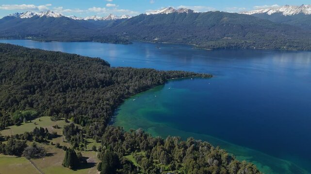 aerial view of Lynch Bay in the Arrayanes Forest, located within Nahuel Huapi Lake in Patagonia, Argentina. The pristine blue waters contrast with the lush green forest.