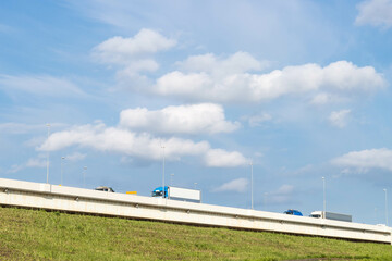 Obraz premium Trucks on road with blue sky and white cloud background, copy space, transport and logistic concept