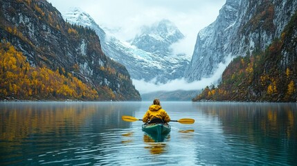 2410_370.a scenic view of a woman kayaking through a mountain lake, the clear cold water reflecting the towering cliffs and snowy mountains, autumn leaves creating a colorful contrast, the adventurer