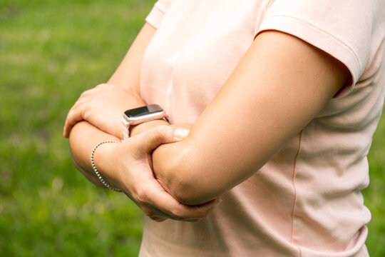 woman has pain in his elbow and tendon muscles and he relieves the pain with a massage. Health and healing concept	