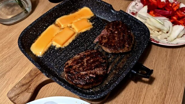 Closeup of sizzling grilled meat and cheese ready for serving with a side of fresh vegetables