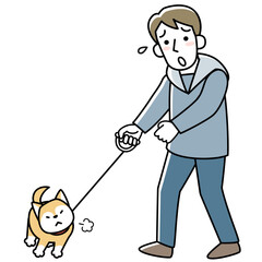 散歩を嫌がる犬と困る飼い主の若い男性
