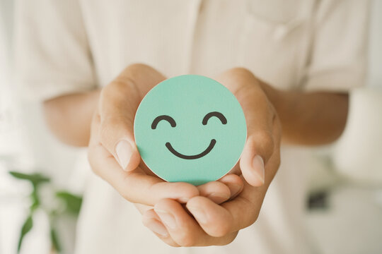 Male Teen holding smile emoji face, positive mental health, world mental health day concept