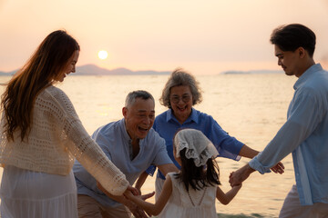 
Group of multi generation family little girl with parents and grandparents relax and enjoy together on the beach.