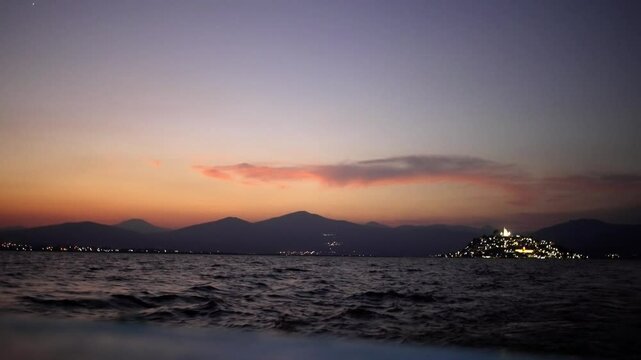 SLOW MOTION: POINT OF VIEW OF JANITZIO ISLAND AT SUNSET FROM A BOAT AT PATZCUARO LAKE IN MICHOACAN