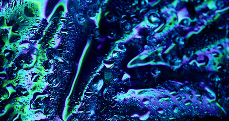 Color raindrop. Flickering lighting. Liquid blinking condensation on glossy wet surface with sparkling spectral splashes trickling down.