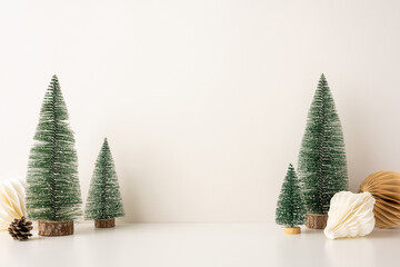 A side view serene, minimalist Christmas scene featuring snow-covered miniature trees and Scandinavian-style decor, evoking a peaceful winter holiday atmosphere © ActionGP